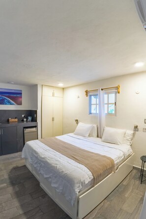 A bedroom with a bed, bedside tables, a wardrobe, and a bathroom.