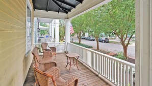 A covered porch with wicker furniture and a view of the street. - Going to Carolina! Historic Downtown Wilmington (Wilmington)