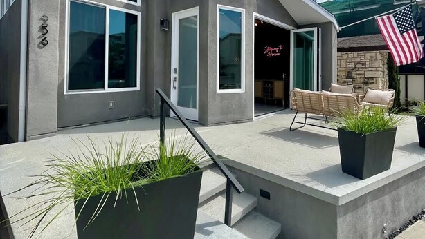 A modern two-story house with large windows, a covered patio, and outdoor seating. - Naples Island rooftop deck/bbq AC & 2 car garage (Long Beach)