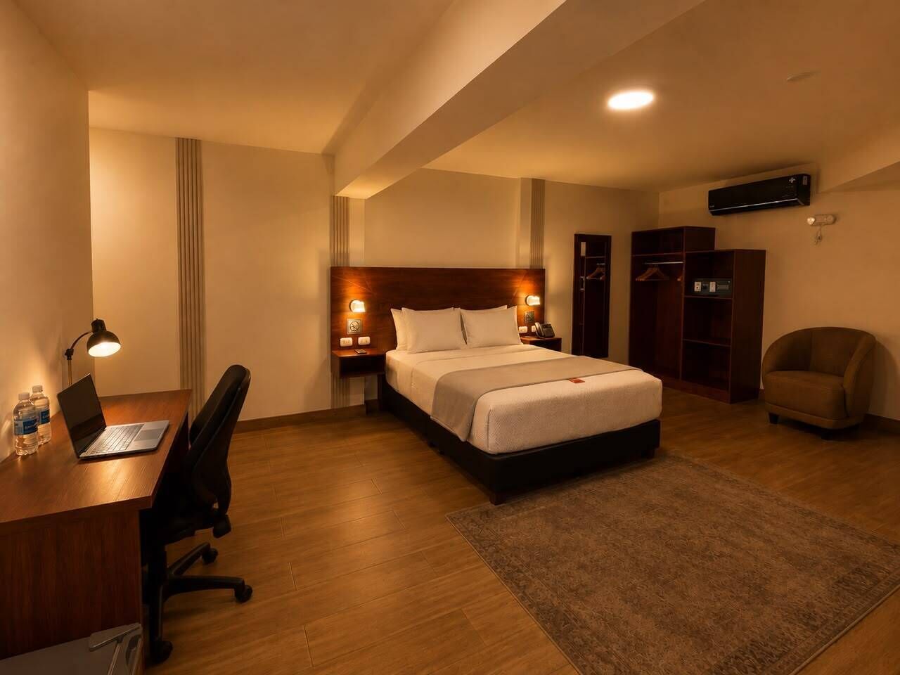 Une chambre d’hôtel équipée d’un lit, d’un bureau, d’une chaise et d’une armoire.