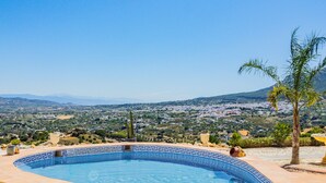 Une piscine offrant une vue sur la ville et les montagnes en arrière-plan.