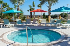 A pool area with lounge chairs, umbrellas, and palm trees. - Luxury Themed Bedrooms Haven (Davenport)