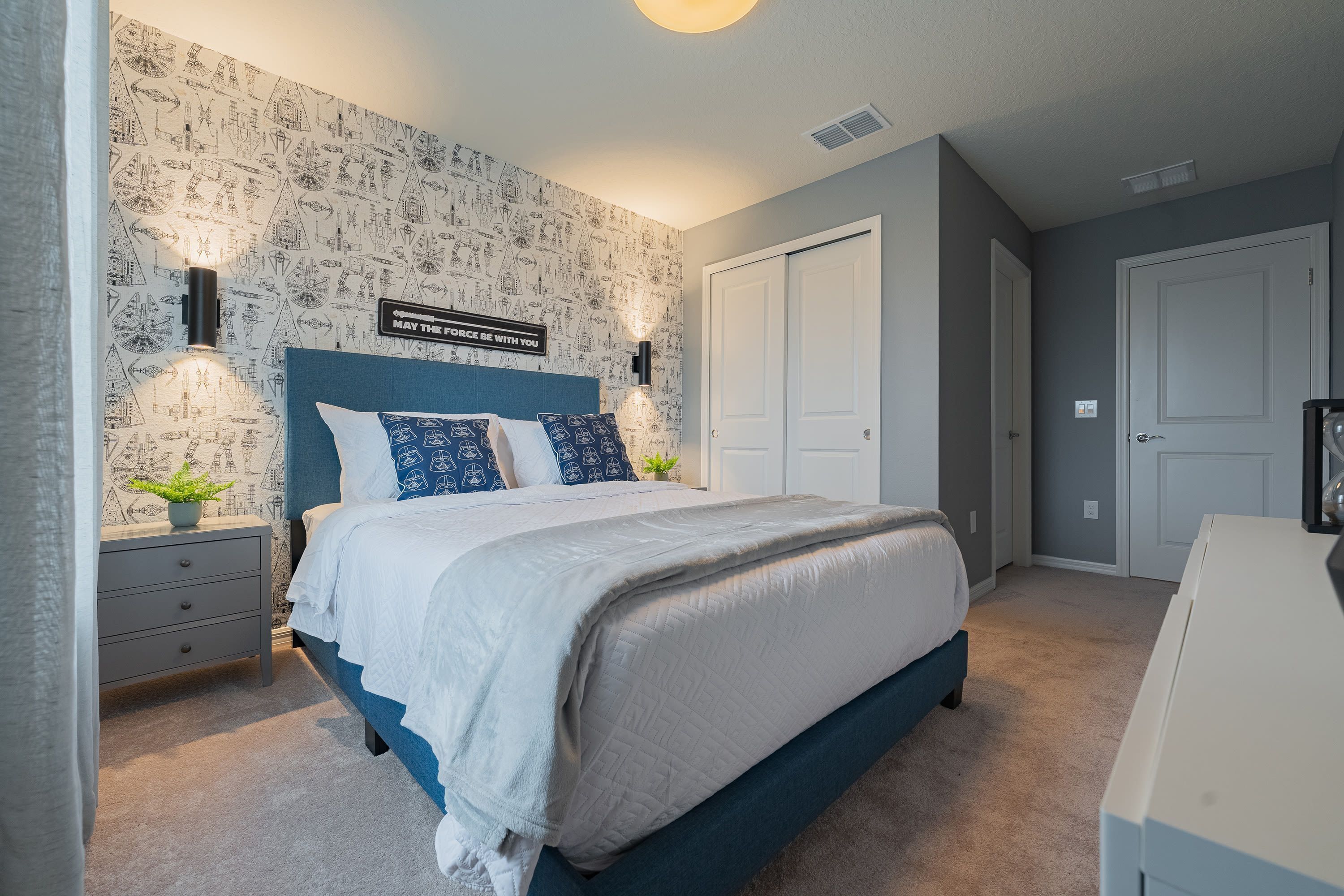 Une chambre à coucher comprenant un lit, des tables de chevet, une commode et une armoire.
