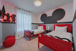 A bedroom with two beds, a red accent wall, and a Mickey Mouse design on the ceiling. - Luxury Themed Bedrooms Haven (Davenport)