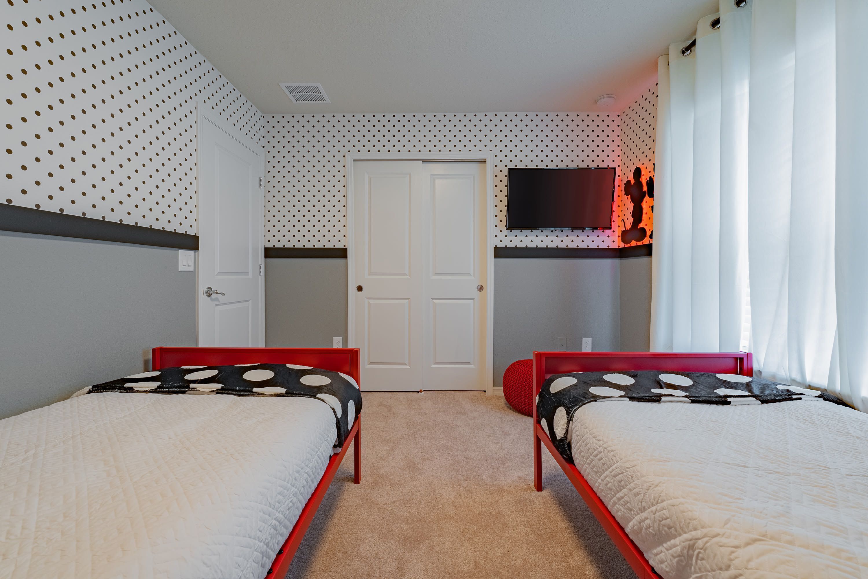 Un dormitorio con dos camas, una televisión y una puerta.