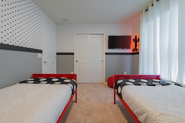 Un dormitorio con dos camas, una televisión y una puerta.