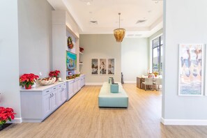 Una cocina amplia con suelo de madera clara, una isla central y una zona de comedor con mesa y sillas.