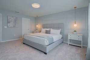 A bedroom with a bed, bedside tables, and a nightstand.