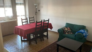 Un coin repas comprenant une table et des chaises, un canapé et une petite table d’appoint.