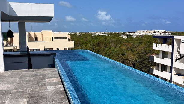 A rooftop swimming pool with a clear view of the surrounding buildings and landscape. - Studio Toh 210 - Elle Residence (Tulum)