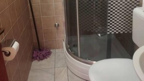 A bathroom with a shower, toilet, and a mop on the floor. - Apartments Natali - One Bedroom Apartment with Balcony (APP3) (Podaca)