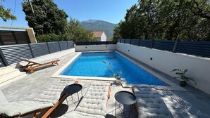 A rooftop pool with lounge chairs and a small table. - Two Bedroom Apartment with Terrace and Swimming pool (Zagvozd)