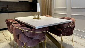 A modern dining area with a marble table, plush velvet chairs, and a decorative candle centerpiece. - Two Bedroom Apartment with Terrace and Swimming pool (Zagvozd)