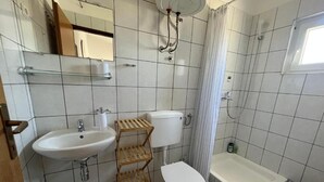 Ein Badezimmer mit Waschbecken, Toilette, Dusche und Spiegel.