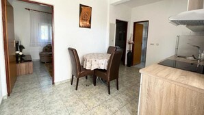 A compact living space with a dining area, kitchenette, and a small seating area. - One Bedroom Apartment with Balcony (3) (Biograd na Moru)
