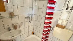 A small bathroom with a shower, toilet, and sink. - Apartments Fortuna - Studio Apartment (Biograd na Moru)