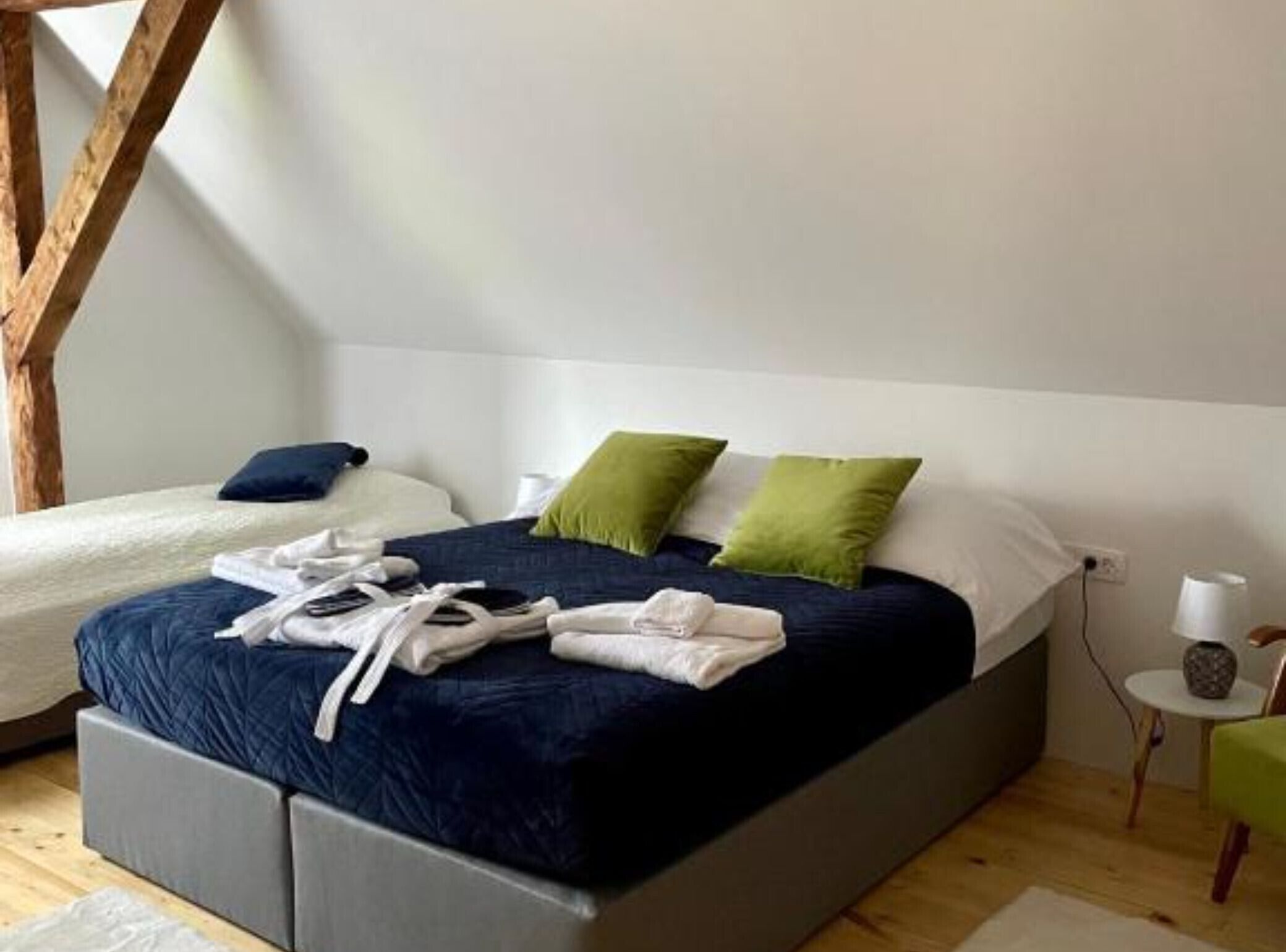 Ein Schlafzimmer mit einem Bett, Kissen und einem kleinen Tisch mit Lampe.