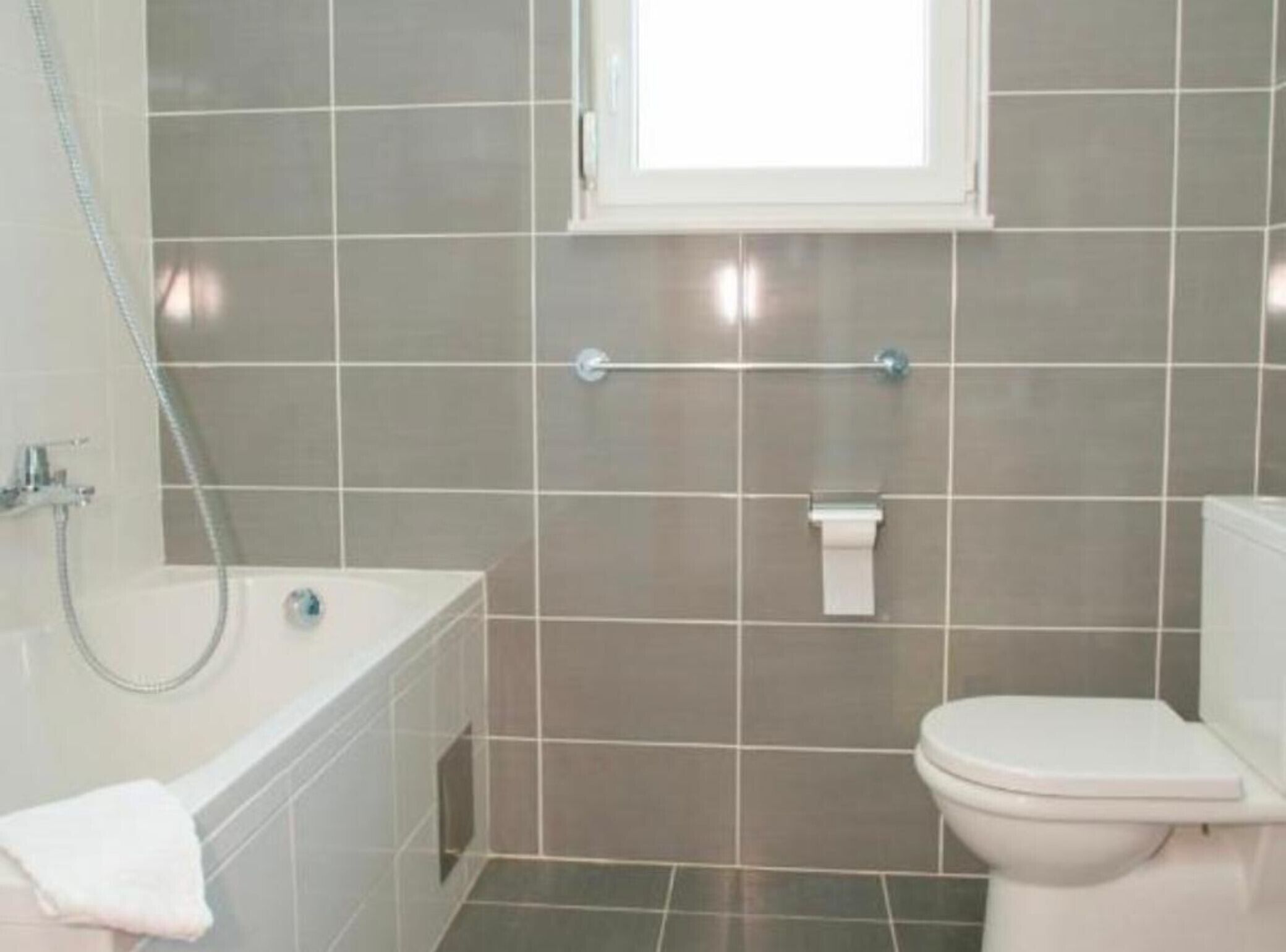Un bagno con vasca, water e finestra.