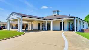 Ein großes Gebäude mit überdachter Einfahrt und Säulen, vermutlich ein Hotel oder ein öffentliches Gebäude.