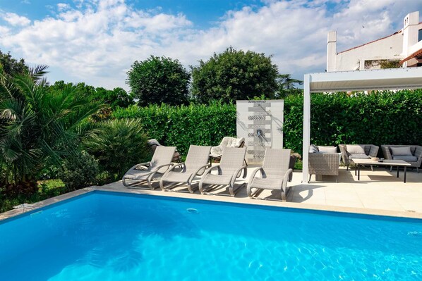 A swimming pool with lounge chairs and a covered seating area. - 6BD villa with heated pool and jacuzzi near sea (Punat)