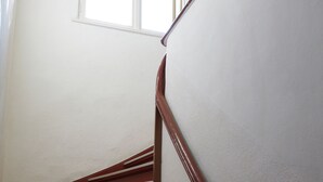 Una escalera con escalones de madera y paredes blancas.