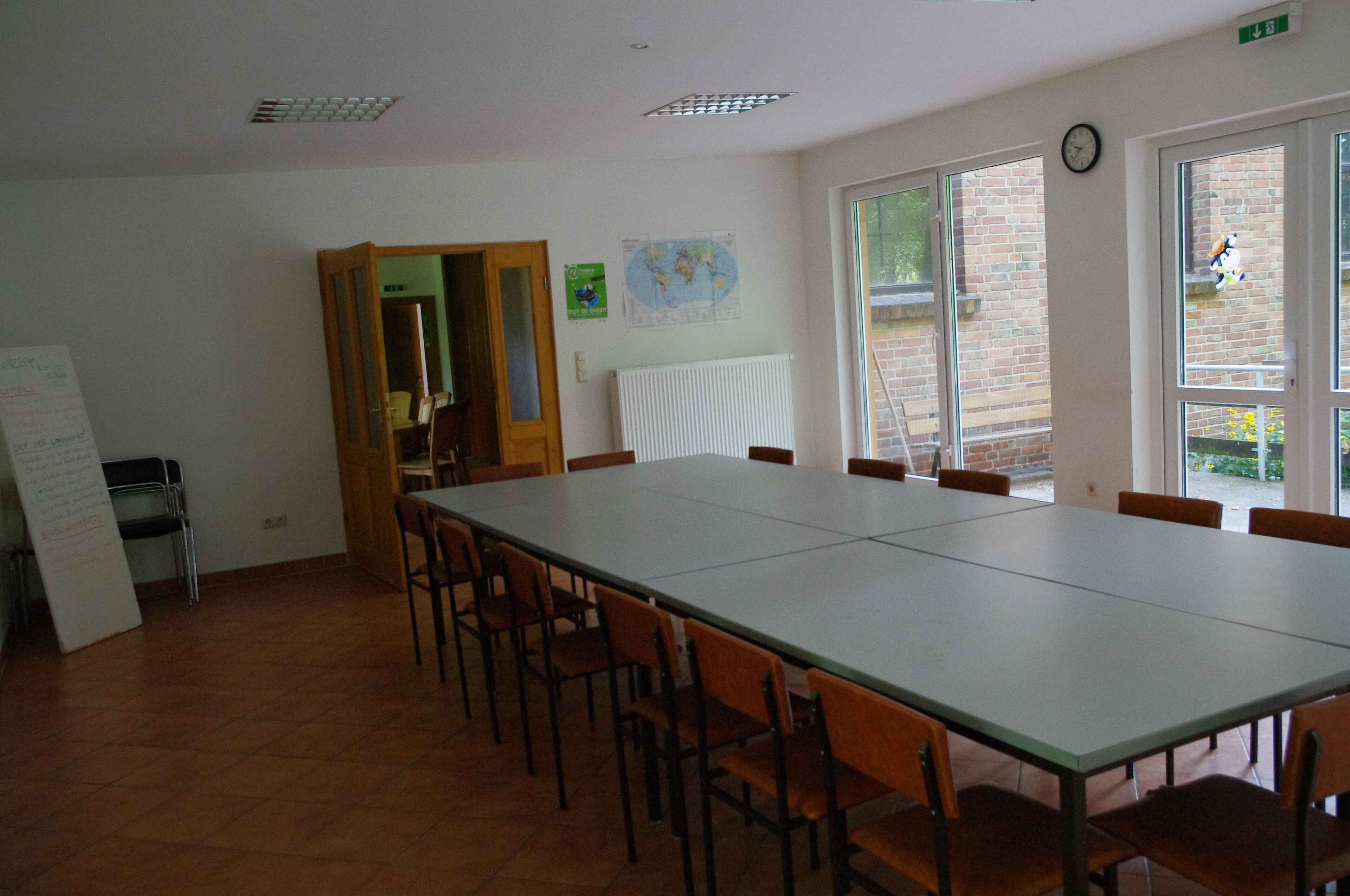 A conference room with a long table and chairs, a whiteboard, and a map on the wall.
