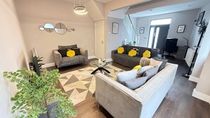 Una sala de estar moderna con dos sofás, una mesa de centro y una planta en maceta.
