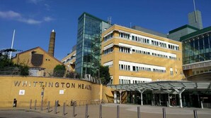 A multi-story building with a yellow facade and a glass structure, labeled 'WHITTINGTON HEALTH.'
