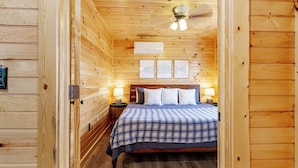 A wooden-paneled room with a bed, a nightstand, and a ceiling fan. - Riverfront Cabin~Firepit~Private Boat Ramp w/ river access~Dog-Friendly! (Jamestown)
