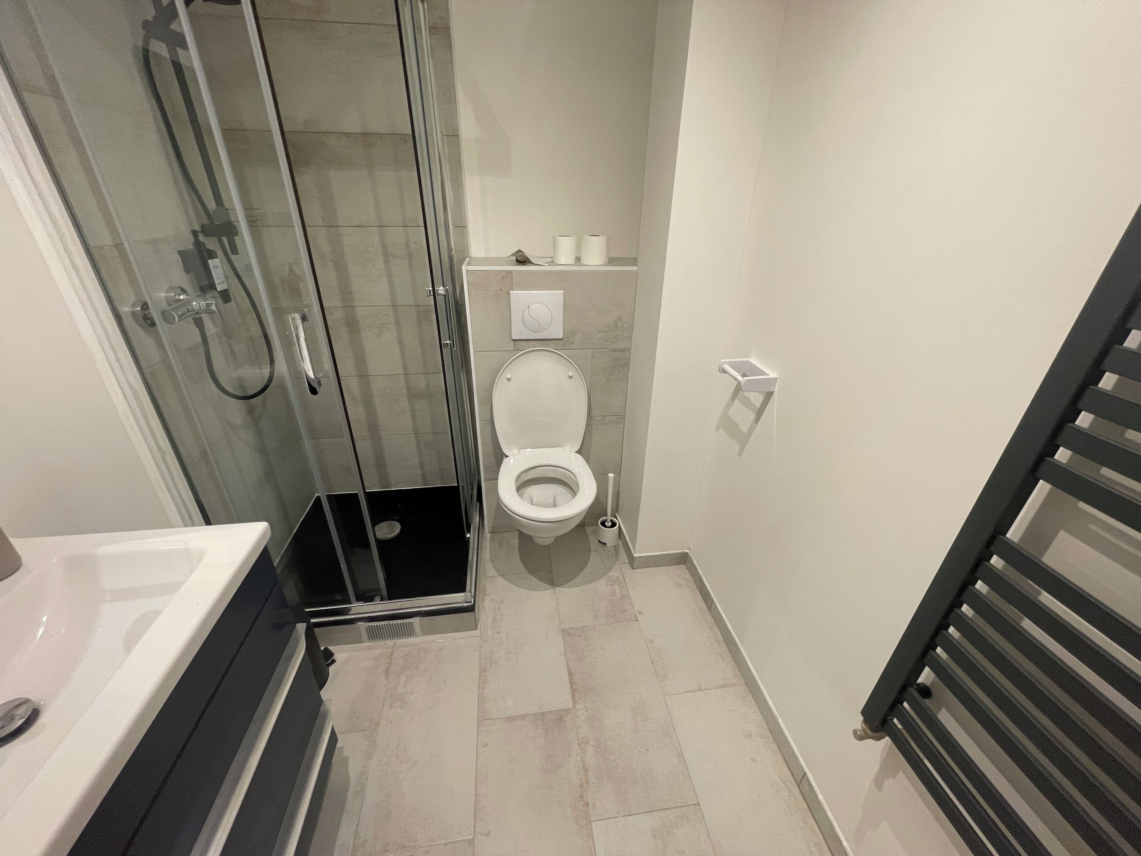 Un bagno moderno con doccia vetro, toilette e vasca da bagno.