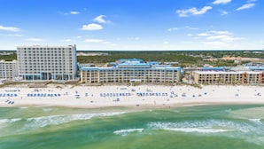 A beachfront hotel with multiple buildings, a sandy beach, and ocean waves. - Continental by Book That Condo (Panama City Beach)