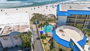 A beach resort with a swimming pool, beach umbrellas, and a view of the ocean. - Continental by Book That Condo (Panama City Beach)