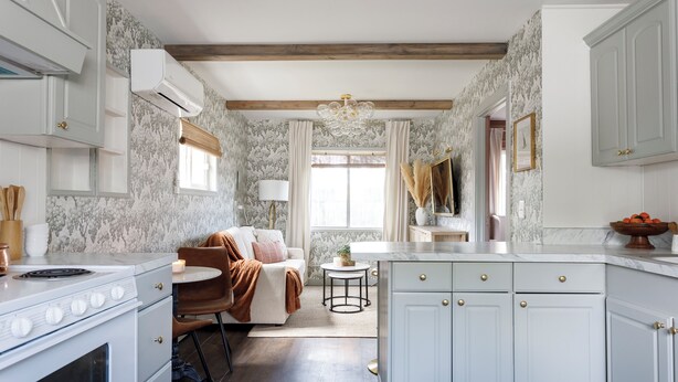 A kitchen with white cabinets, a marble countertop, and a built-in oven. There is a dining area with a table and chairs, and a window with curtains. - Charming Cottage on the Boise Bench. Minutes from downtown, BSU & the airport. (Boise)