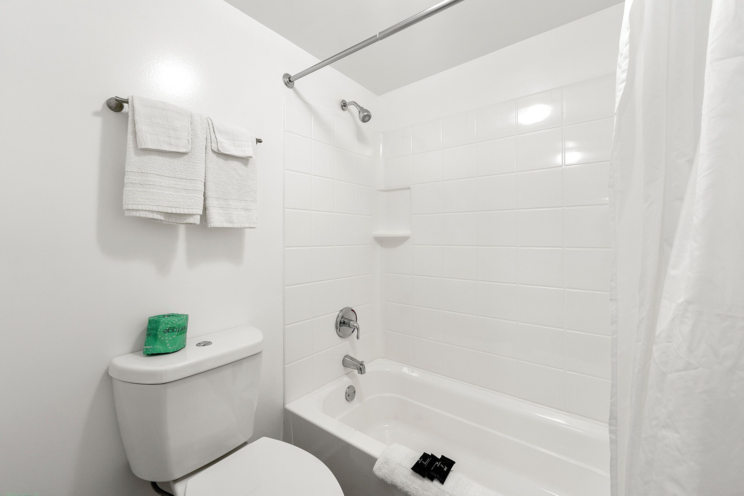 Un baño con inodoro, bañera y cortina de ducha.