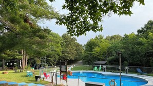 A fenced backyard with a swimming pool, lounge chairs, and a small shed. - RV Site #42 pull through - Big Rig Friendly 65ftx28ft (Hardin)