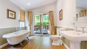 Ein Badezimmer mit freistehender Badewanne, Toilette und Waschbecken.
