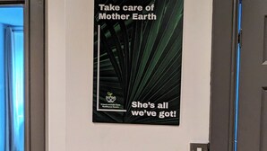 A hallway with a poster on the wall that reads "Take care of Mother Earth She's all we've got!"