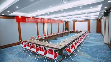 A conference room with a long table, chairs, and a whiteboard.