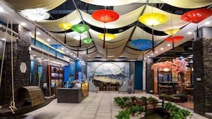 A lobby with a reception desk, seating area, and a small water feature. - Sanhe International Hotel (Jinhu)