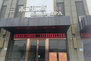 Um edifício com uma placa que diz 'SPA' e um painel digital acima da entrada.