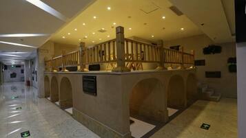 A reception area with a counter, arched doorways, and a wooden railing.