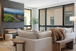 Relax in this cozy living space with a large flat-screen TV, comfortable sofa, and fireplace.