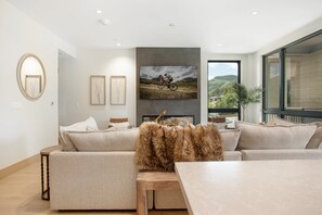Un salon moderne avec un canapé, une table basse et un téléviseur fixé au mur.