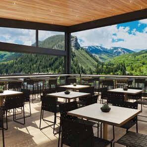 Un restaurant doté d’une terrasse offrant une vue sur un paysage montagneux.