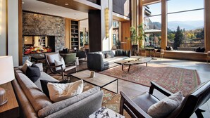 A spacious living area with a fireplace, comfortable seating, and large windows offering a view of the mountains. - CRBC-Best of the Best! Brand New! Ski in/out, Resort & Spa, Hot tub, Ski Valet (Avon)