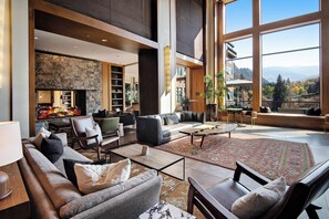 Relax in a spacious living area with a fireplace, comfortable seating, and expansive views.