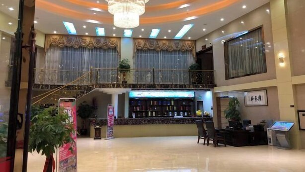 A spacious lobby with a chandelier, a reception desk, and a staircase leading to an upper level. - Red Apple Hotel (Luoyuan)