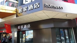A hotel with a modern facade, featuring signage in both Chinese and English, and a visible entrance with glass doors.