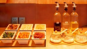 A buffet setup with various food items and condiments.