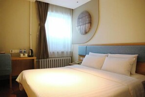 A hotel room with a large bed, a bedside table with a lamp, a window with curtains, and a wall-mounted artwork. - Homeinn Hotel (Jixi Jinlong Building Railway Station Wanda Plaza) (Jixi)